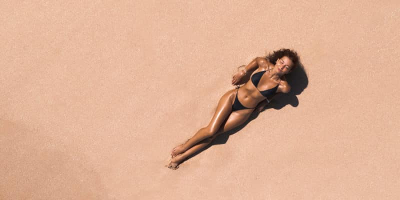 Aerial View of Woman in Bikini on Ideal Pink Sand Beach at the Sea