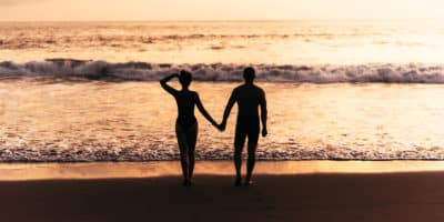 Silhouette of loving couple on sea. A couple in love at sunset. Man and woman meet sunset