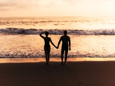 Silhouette of loving couple on sea. A couple in love at sunset. Man and woman meet sunset